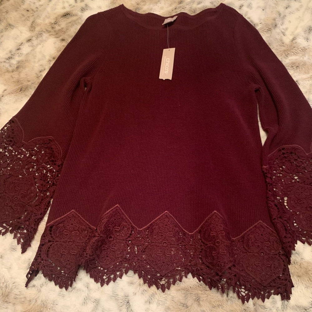 Chico’s elegent sweater with embroidered lace on the sleeves and bottom. Size 0